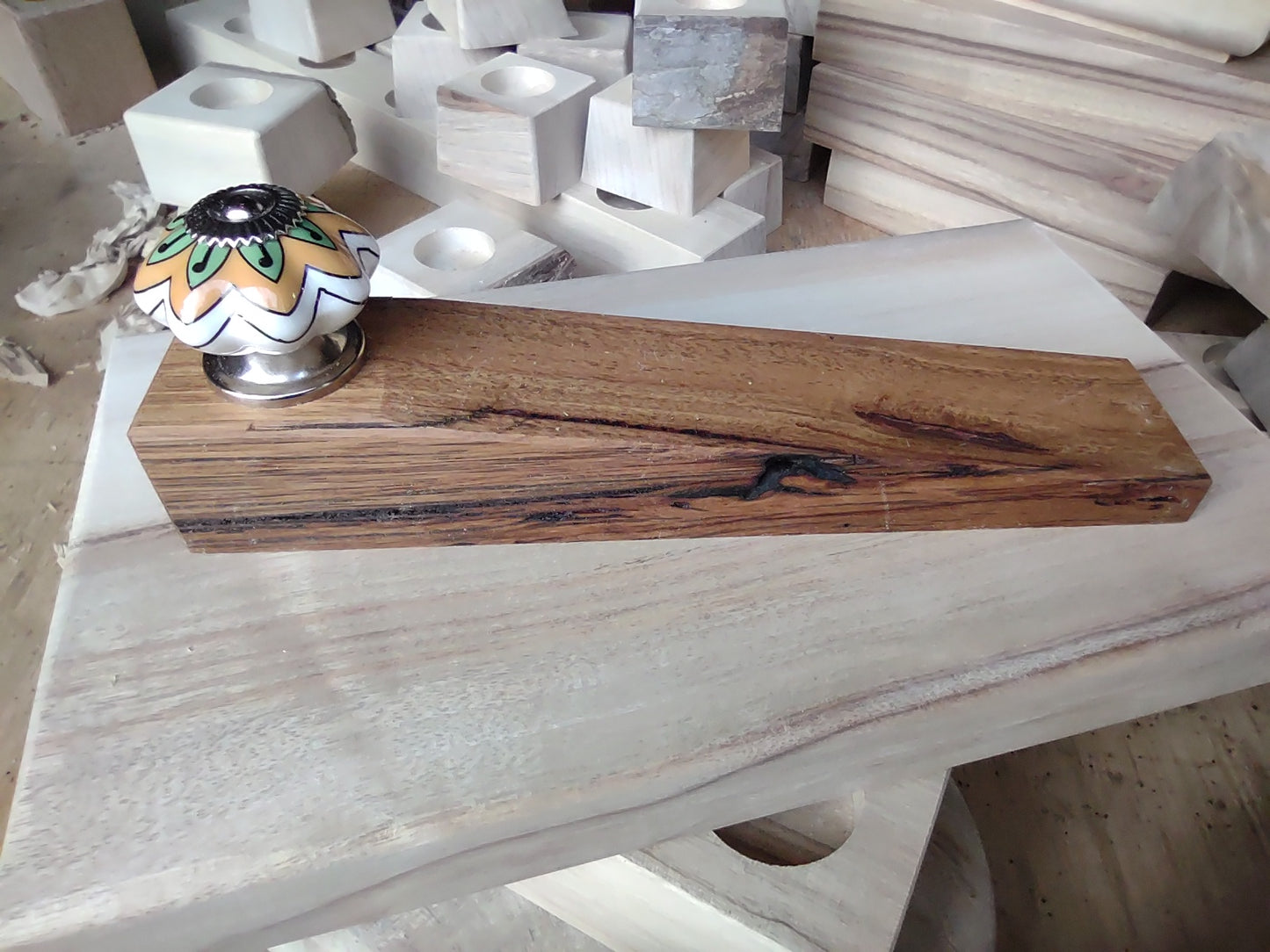 Door stop, White/Orange/Green knob on blonde timber.